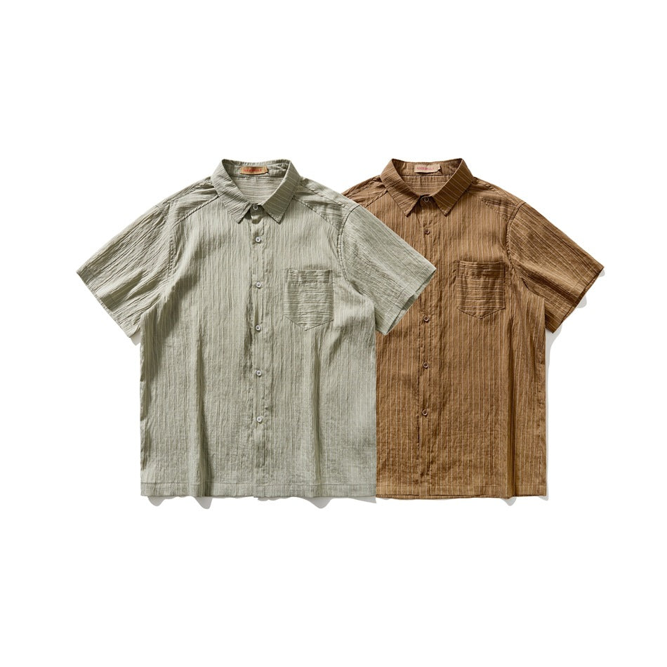 Two short-sleeve button-up shirts with chest pockets, in olive gray and brown, shown side by side.