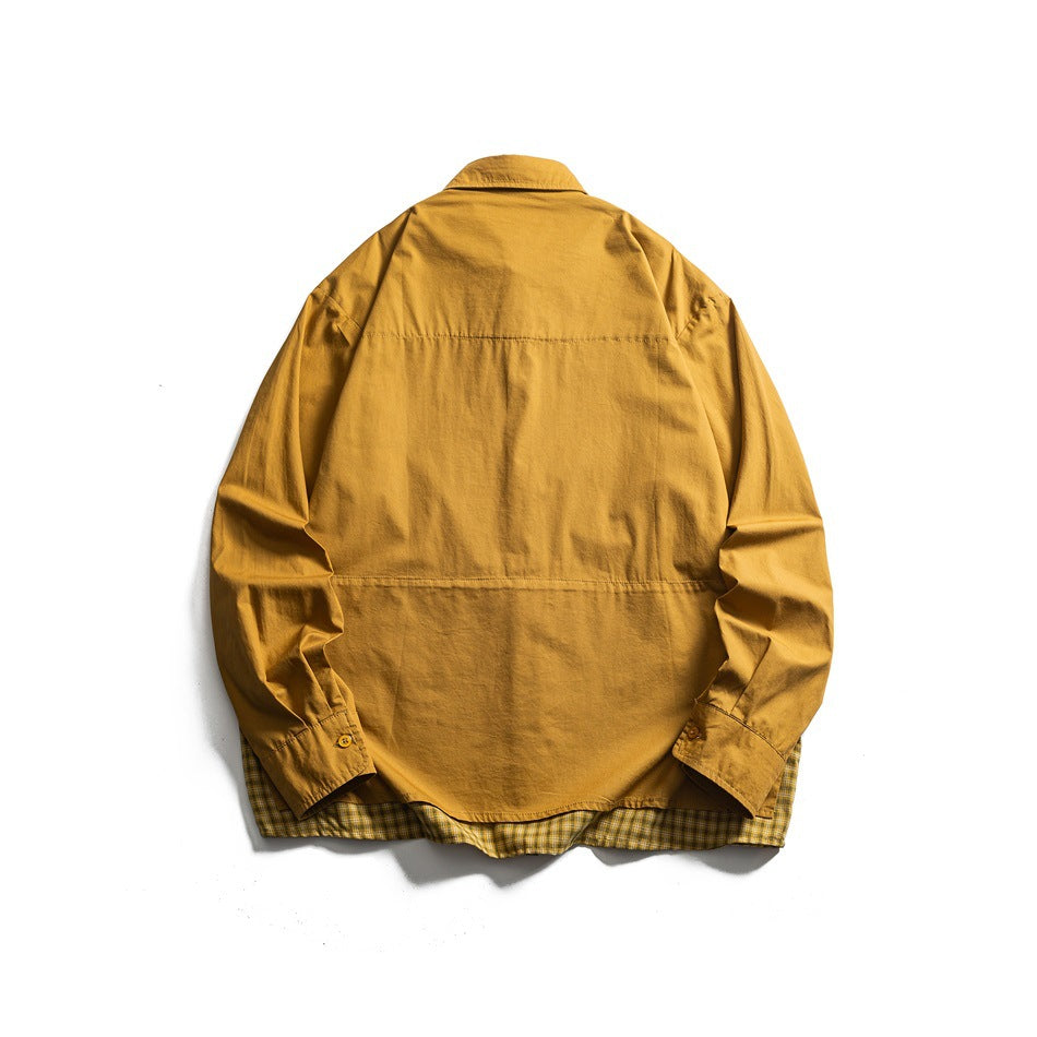 Back view of a mustard long-sleeve button-up shirt with a pointed collar and plaid fabric peeking below the hem.