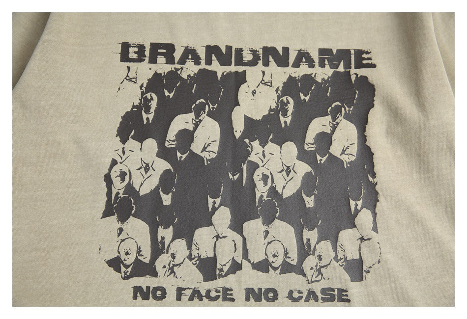 Close-up of a dark graphic with suited figures and distressed English lettering on a sand-beige T-shirt.