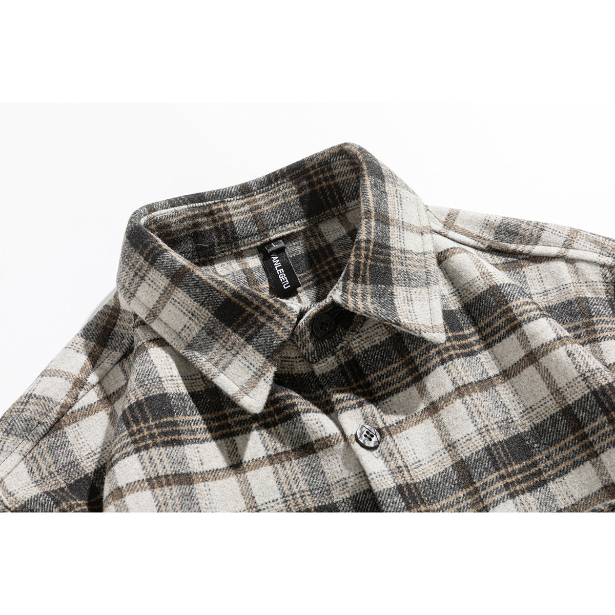Close-up of a cream, gray, and brown plaid shirt collar with black buttons and a visible neck label.
