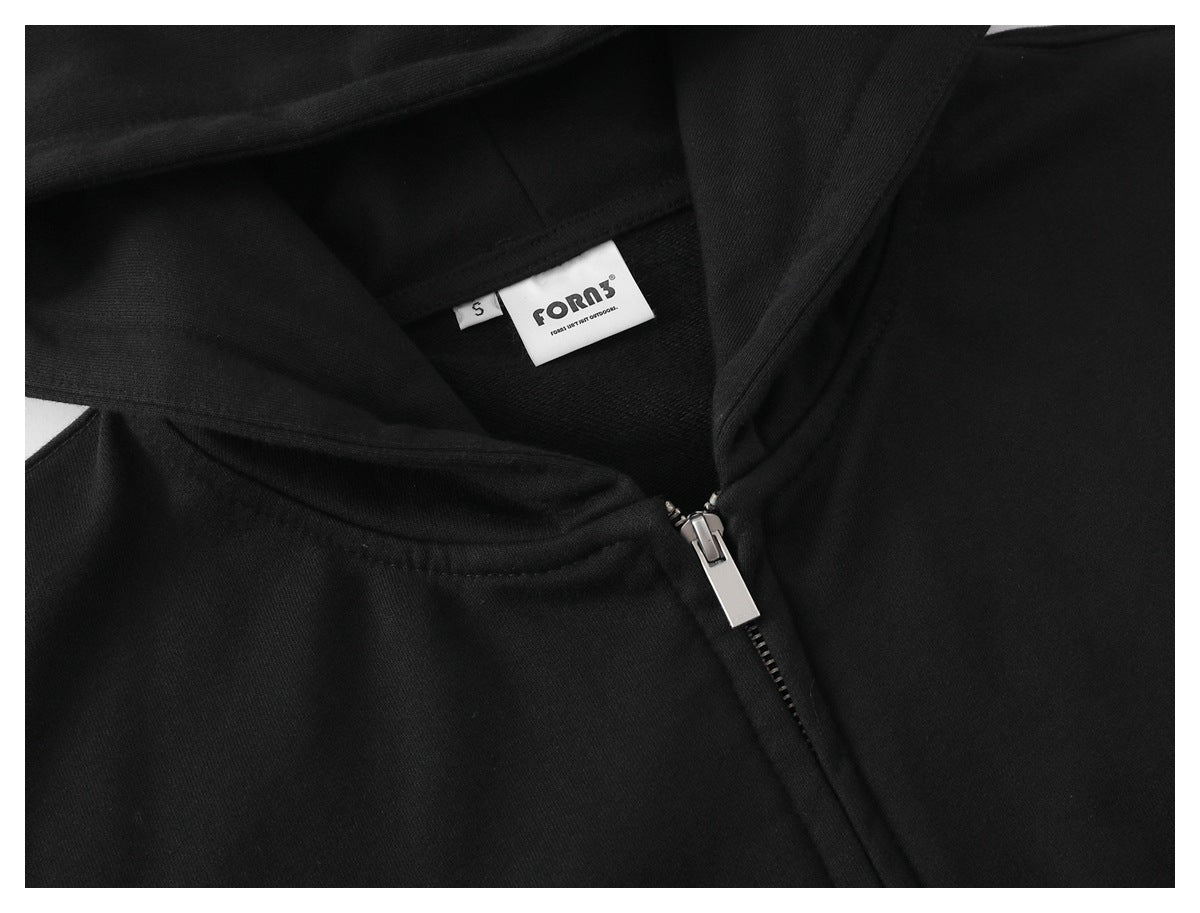 Close-up of a black garment neckline with a silver zipper and a sewn brand and size label.