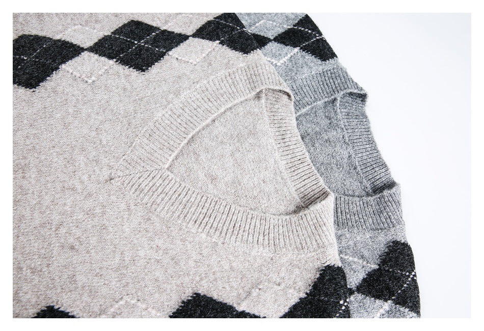 Close-up of overlapping beige and gray V-neck sweaters, showing ribbed necklines and black argyle diamonds.