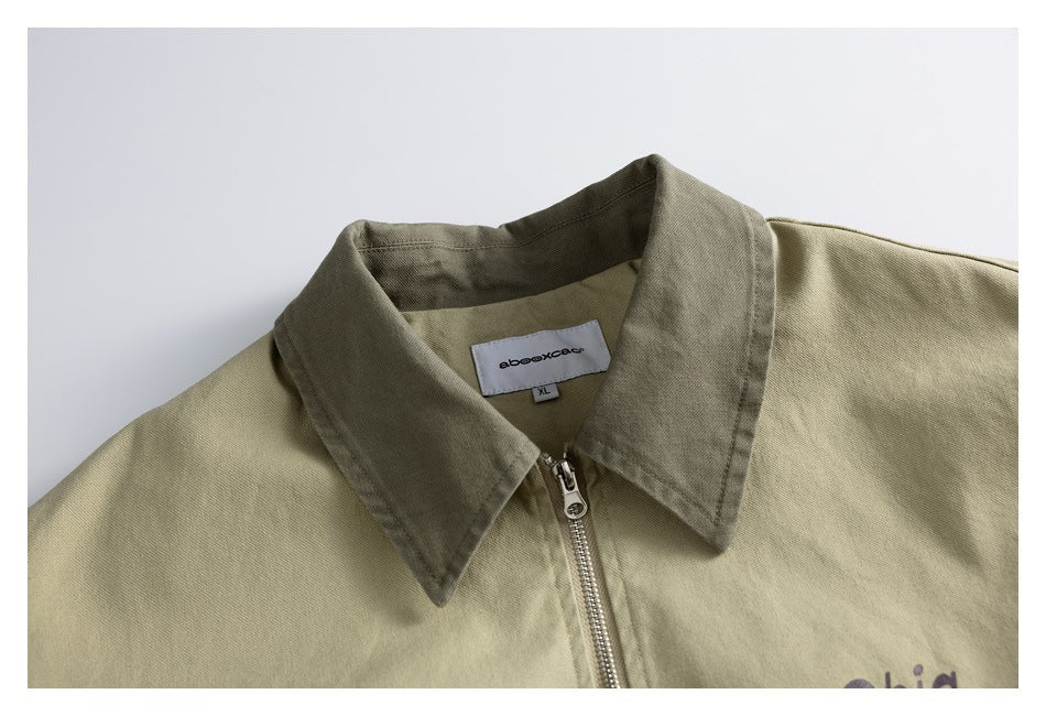 Close-up of a khaki jacket's dark olive collar, center zipper, and neck label.
