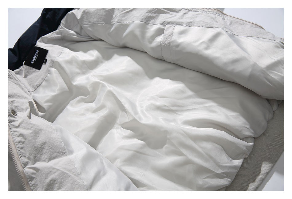 Light gray jacket opened flat to show its pale lining, inner seams, and sewn neck label.