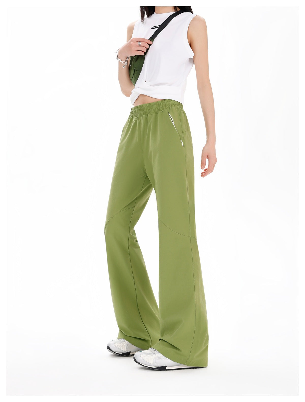 Three-quarter view of a model wearing olive-green wide-leg pants with an elastic waist and side pockets.