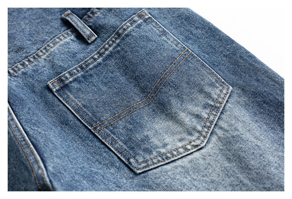 Close-up of a stitched back pocket on blue denim jeans.