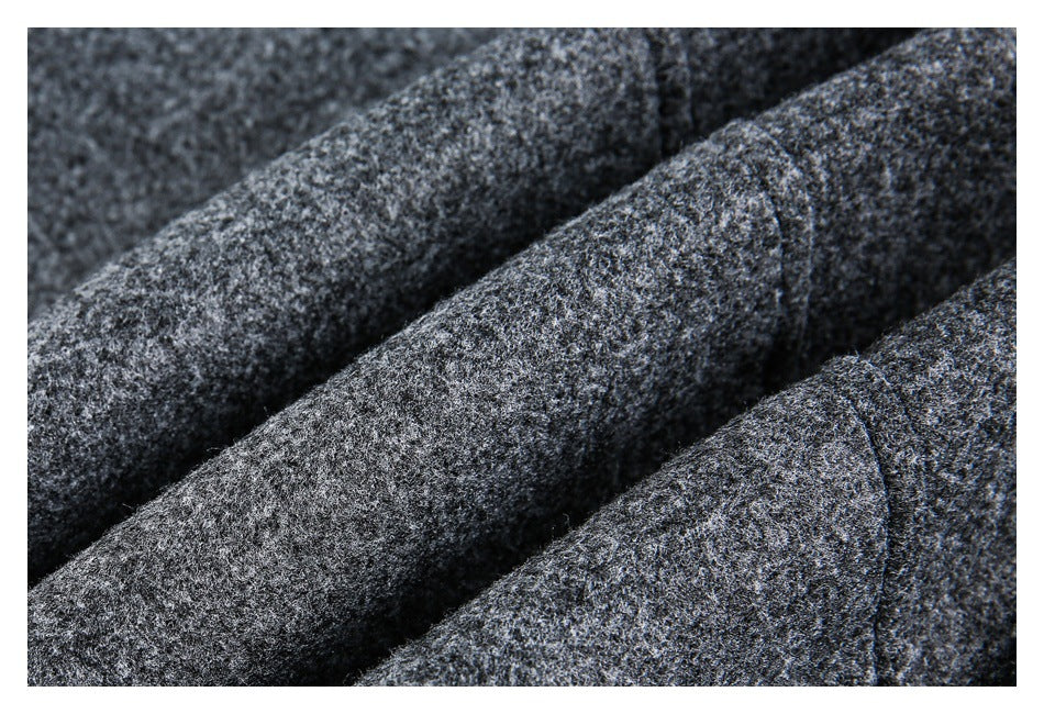 Macro view of the dark gray garment's textured surface, folded edges, and stitching.