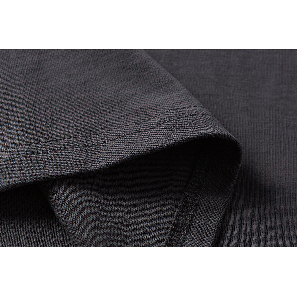 Close-up showing the dark charcoal T-shirt's fabric, folded edge, and double-stitched seam.