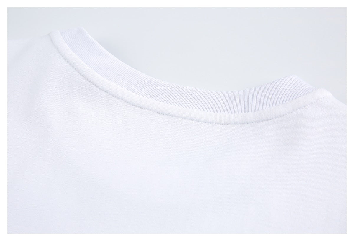 Close-up of a white garment's ribbed crew neckline and collar stitching.