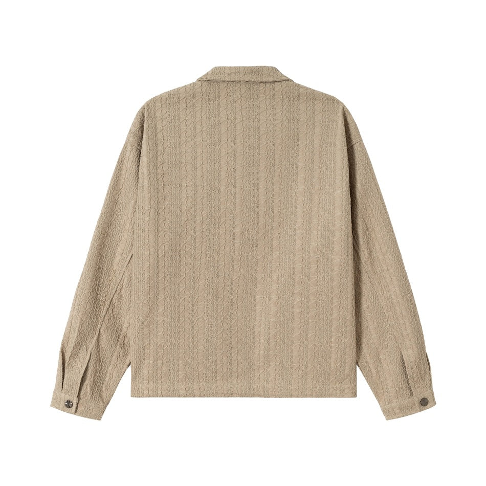 Back view of a beige jacket with a textured pattern, collar, long sleeves and buttoned cuffs on a white background.