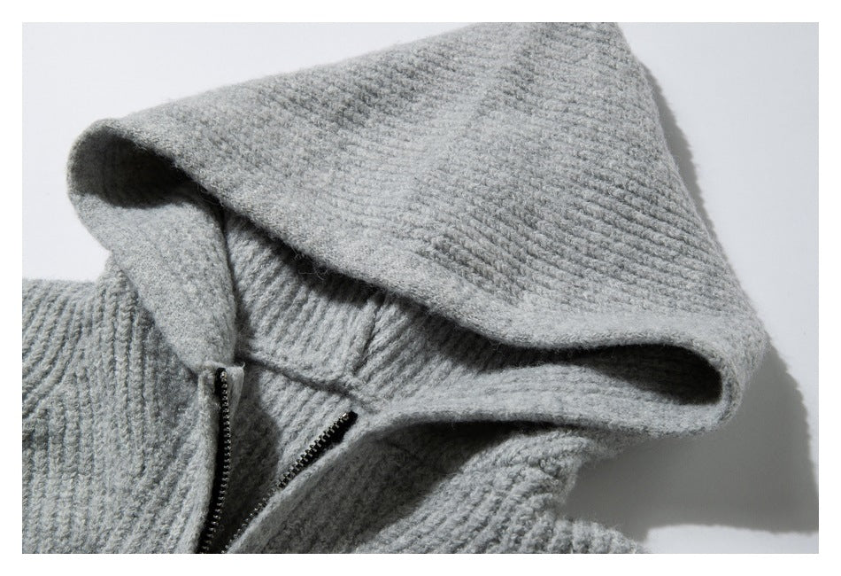 Close-up of a light gray rib-knit hood and short black zipper on a sweater.