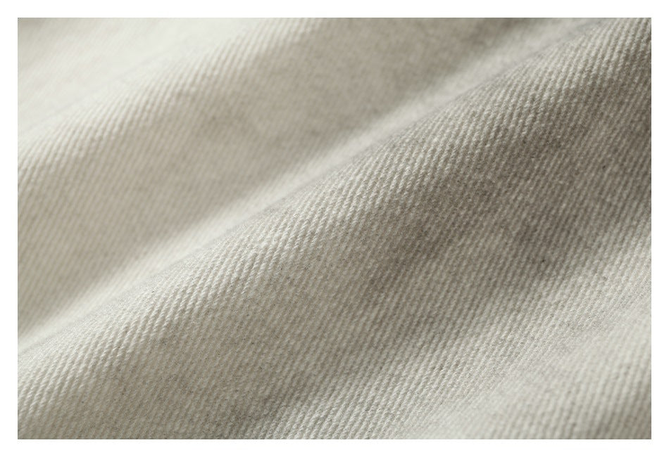 Close-up of light beige fabric showing a fine ribbed texture and soft folds.
