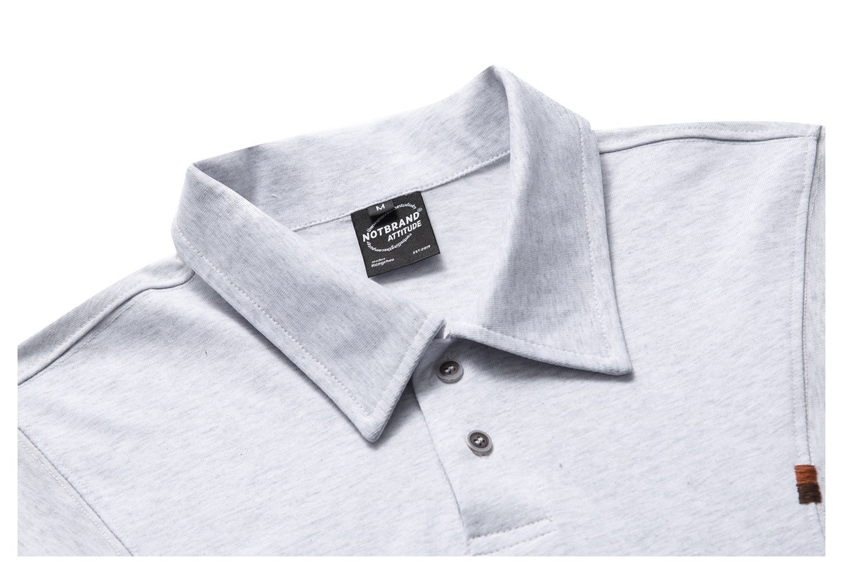 Close-up of a light gray polo shirt collar, two-button placket, and black neck label.