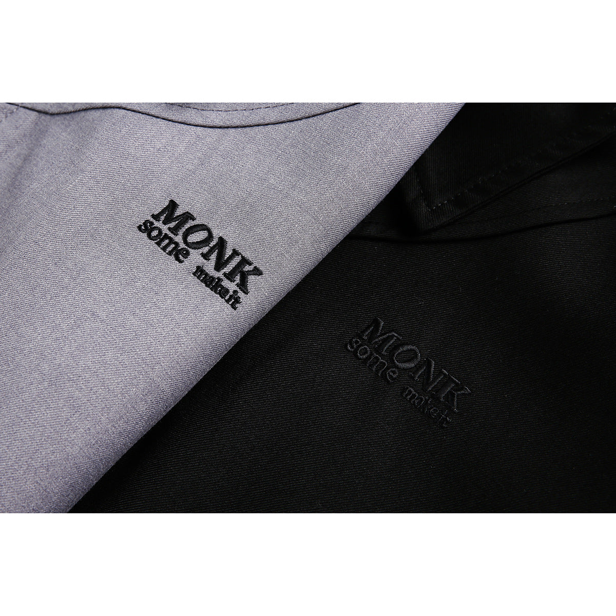 Close-up of black embroidered logos on gray and black jacket fabric.
