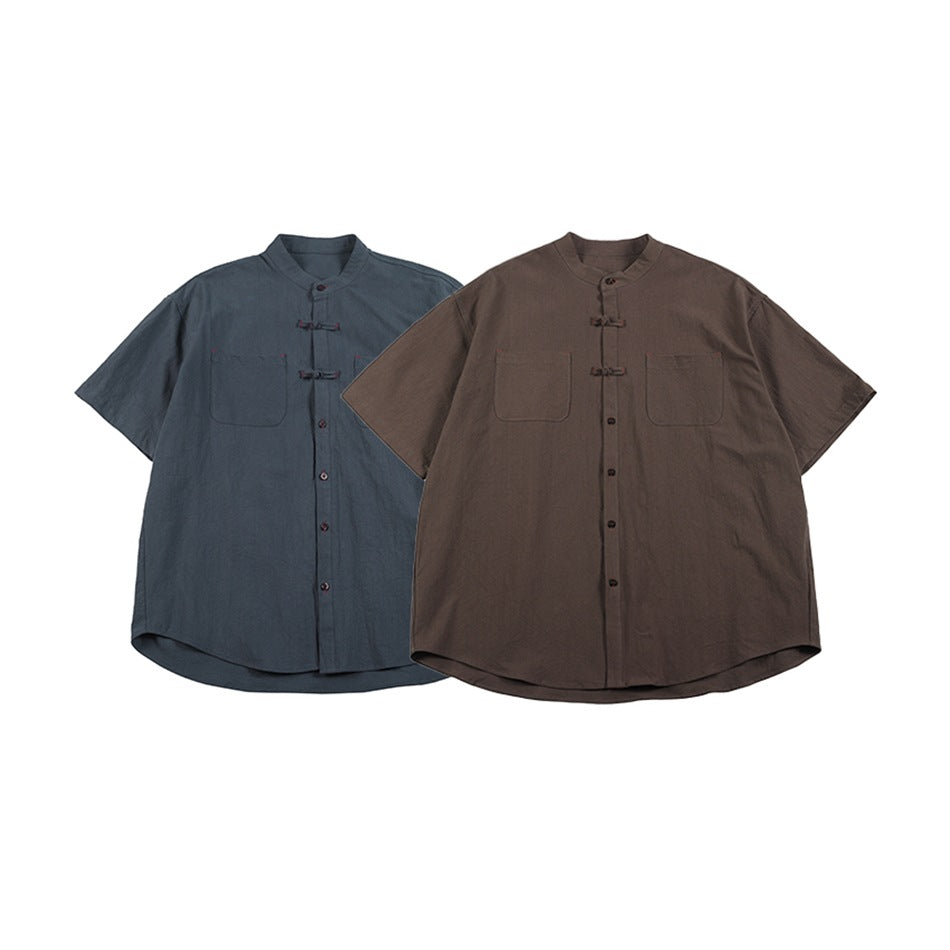 Two short-sleeve stand-collar shirts shown from the front in slate blue and brown.