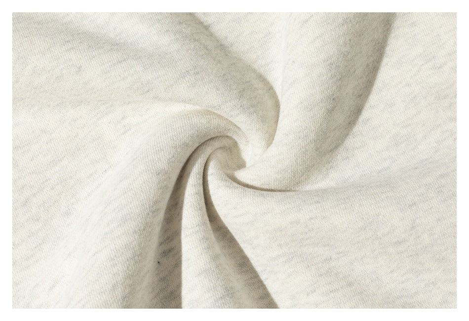 Close-up of the heathered off-white sweatshirt fabric gathered into a twist.
