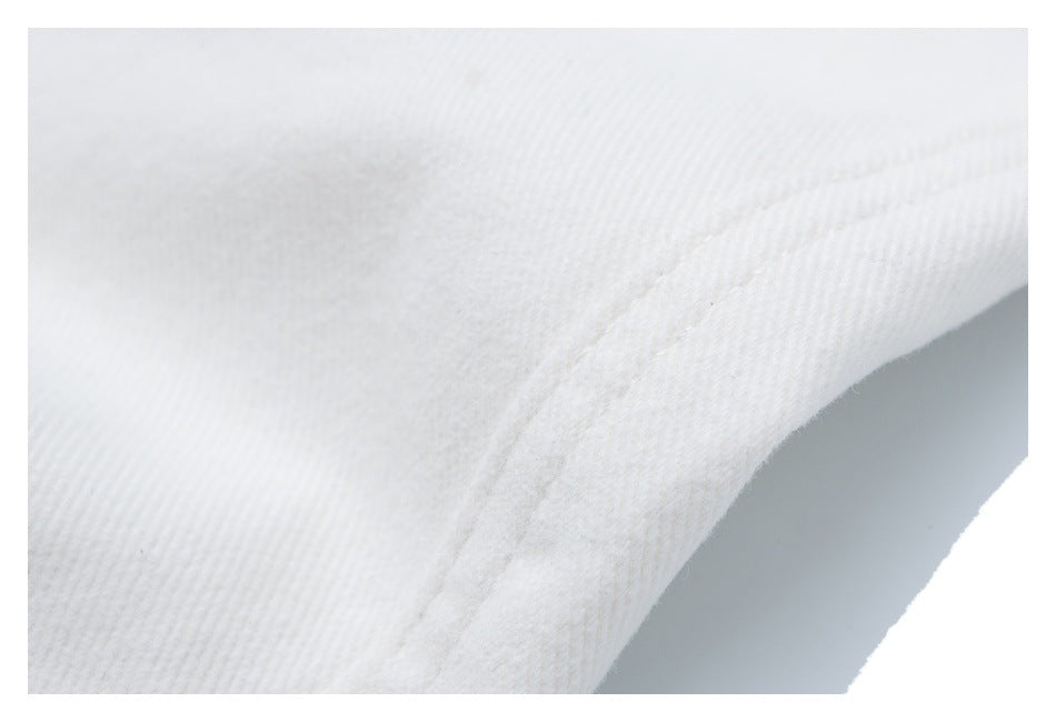 Extreme close-up of white twill fabric and a curved stitched seam.