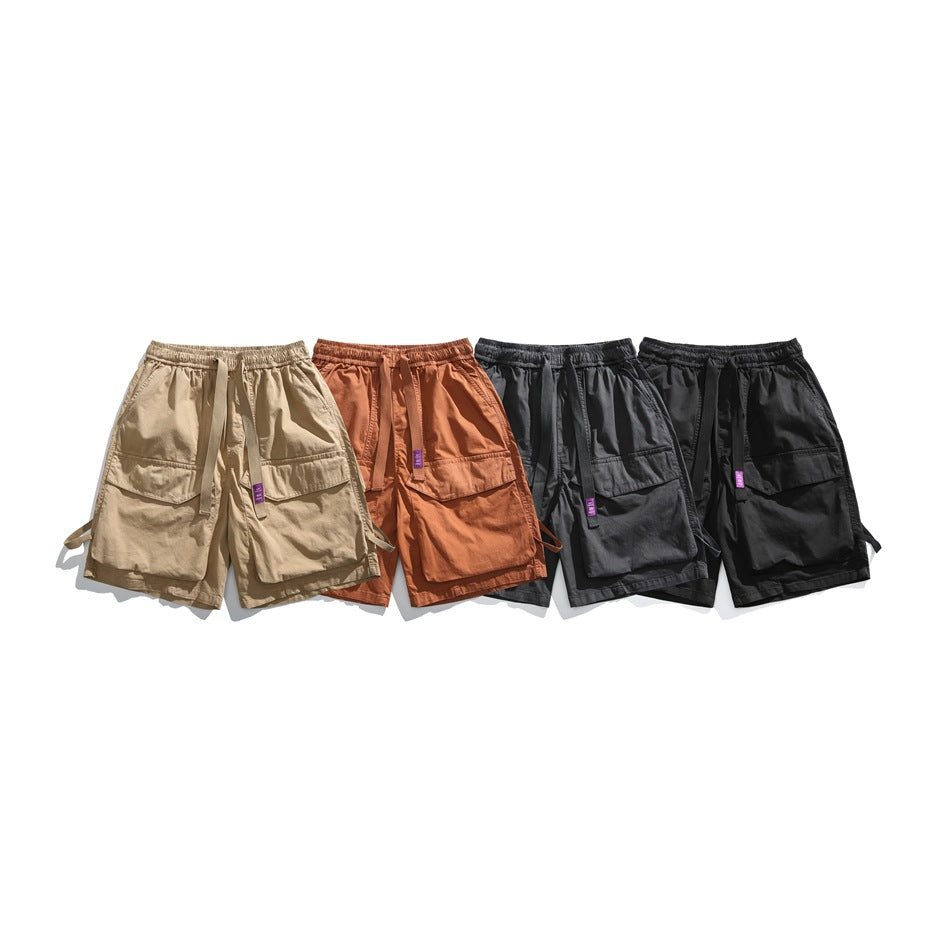 Four pairs of cargo shorts with elastic waistbands, shown in tan, rust, charcoal gray, and black.