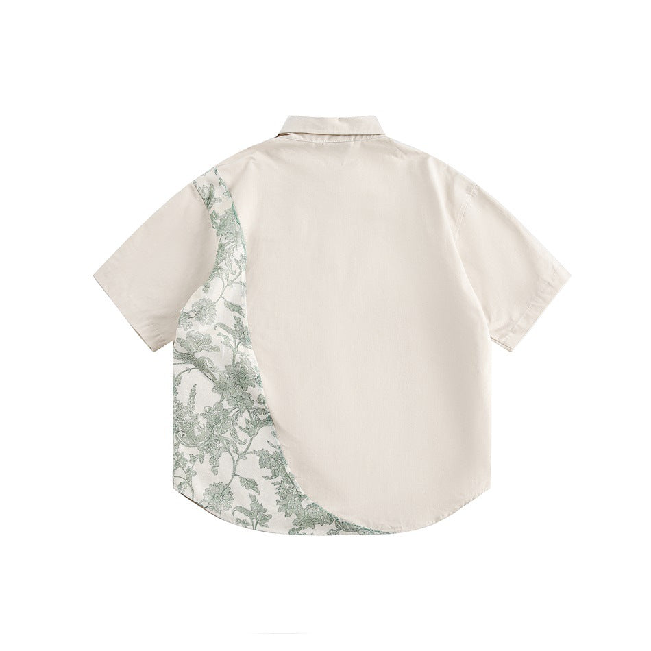 Back view of beige short-sleeve shirt with a curved green floral panel along one side, flat lay