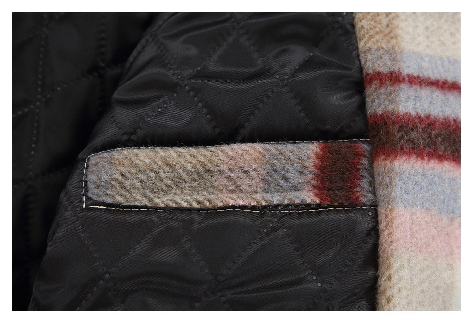 Close-up of a narrow plaid-trimmed pocket inside the coat beside its black quilted lining.