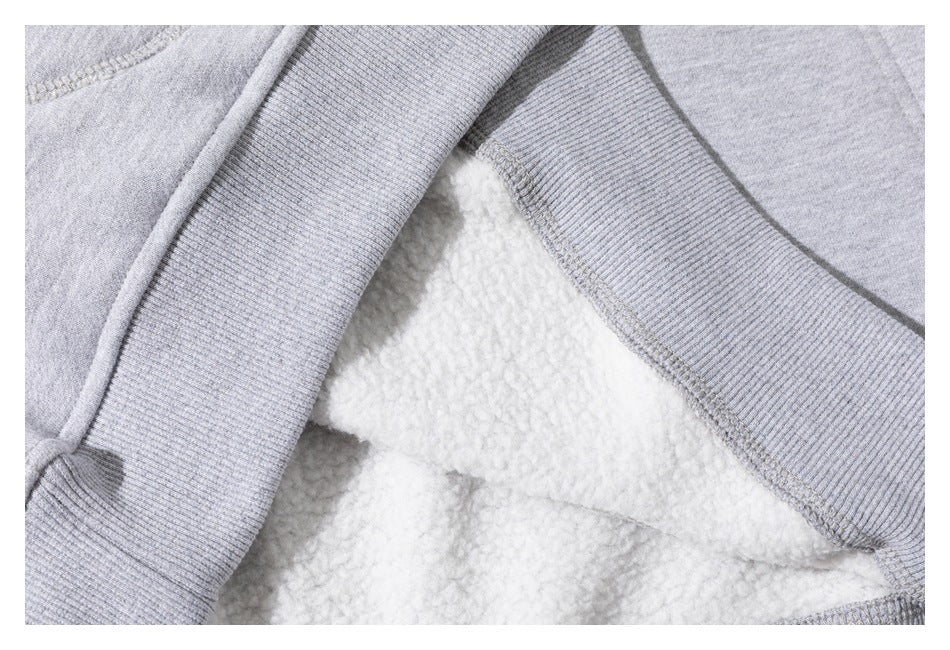 Close-up showing the white fleece-like inner surface and ribbed trim of a light gray sweatshirt.