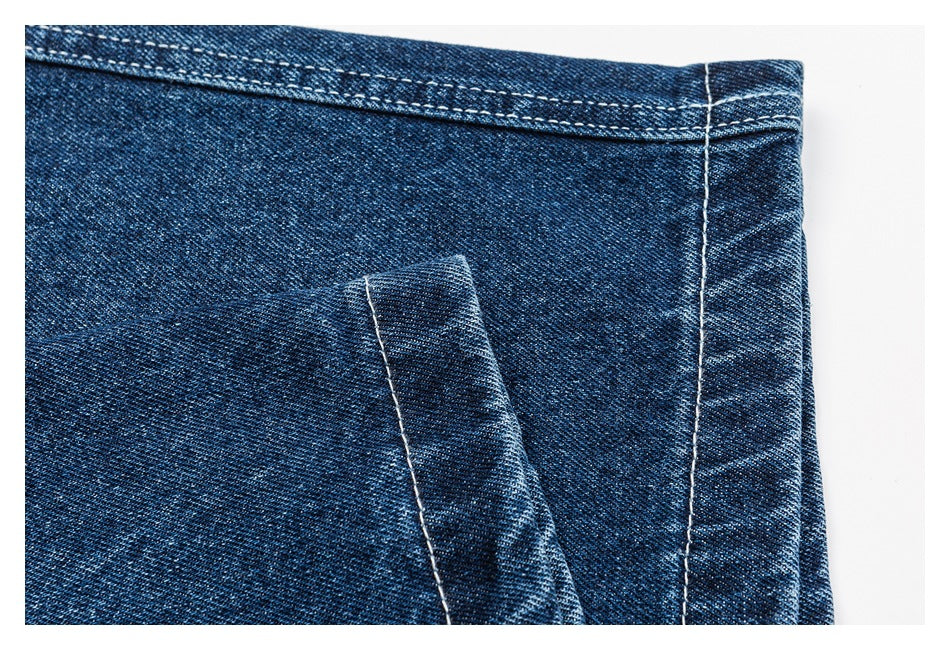 Close-up of blue denim shorts showing the leg hem, stitching, and folded fabric edge.