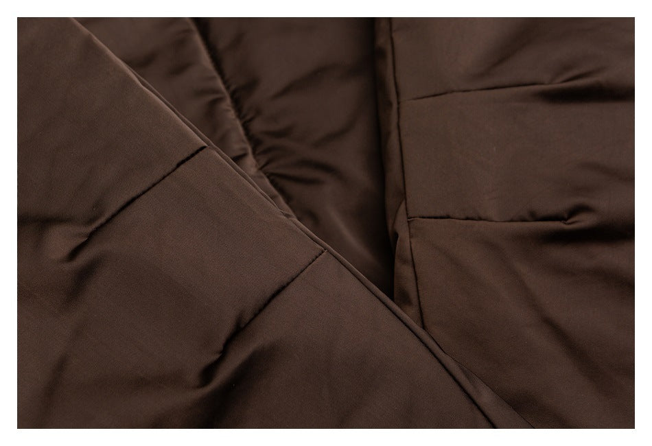 Close-up of dark brown padded garment panels and intersecting seams.