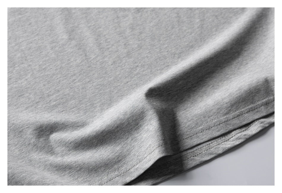 Close-up of the lower hem and fabric of a heather gray T-shirt.