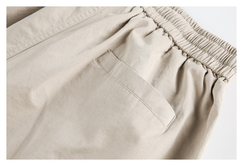Close-up of beige pants with an elastic waistband and a slanted side pocket.