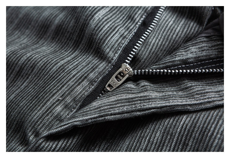 Close-up of an open metal zipper on gray striped trousers.