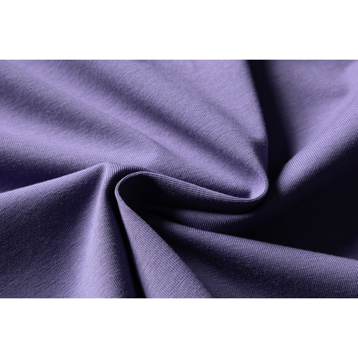 Macro view of purple T-shirt fabric gathered into folds, showing its surface texture.
