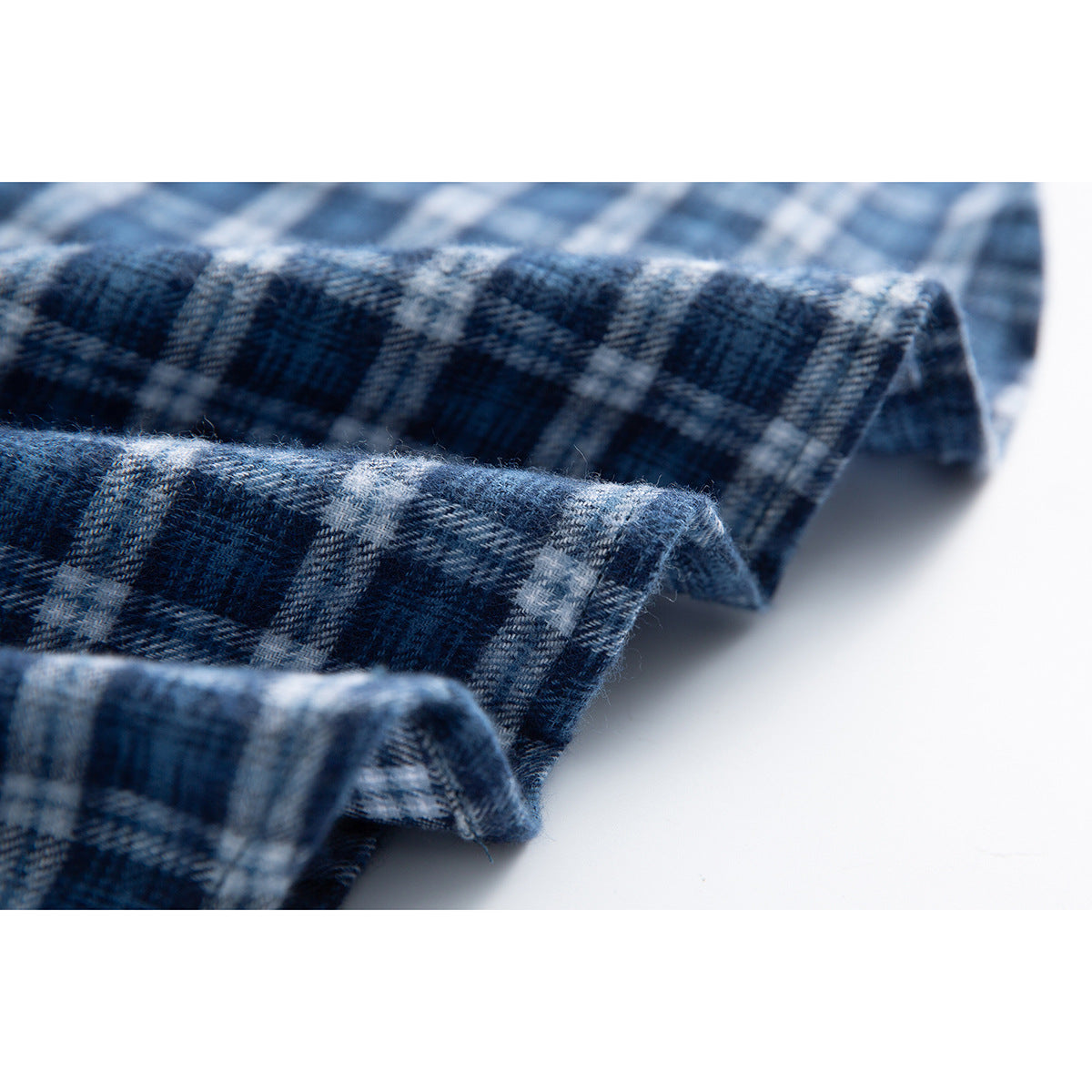 Close-up of the folded edge and plaid fabric texture of a blue-and-white shirt.