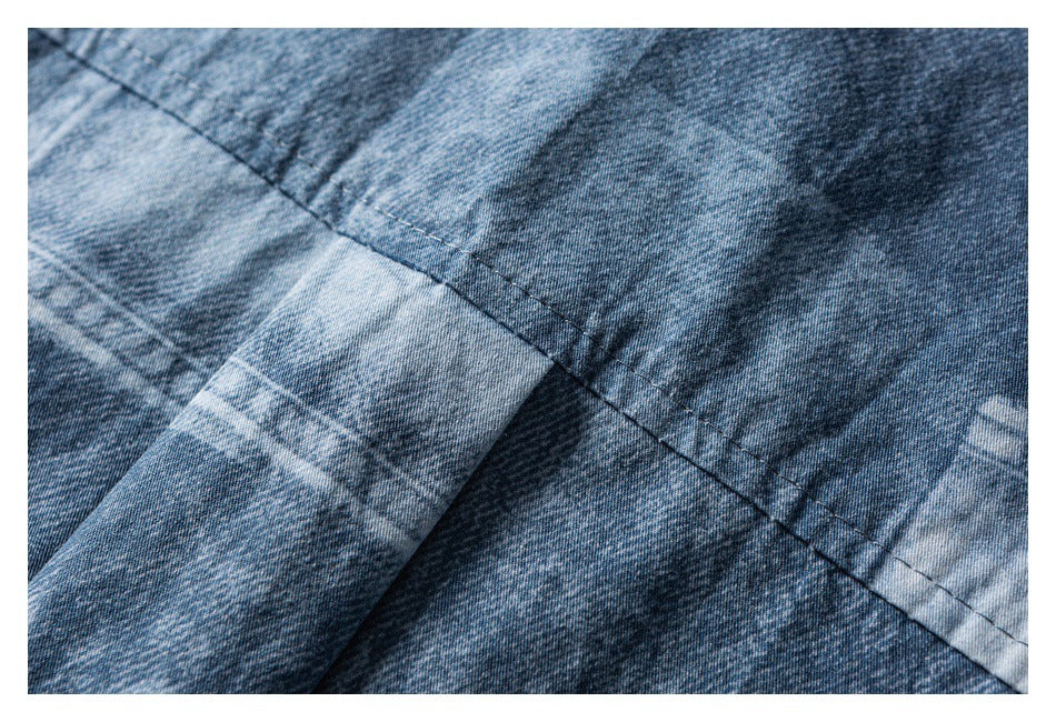 Close-up of intersecting stitched seams on mottled blue denim.