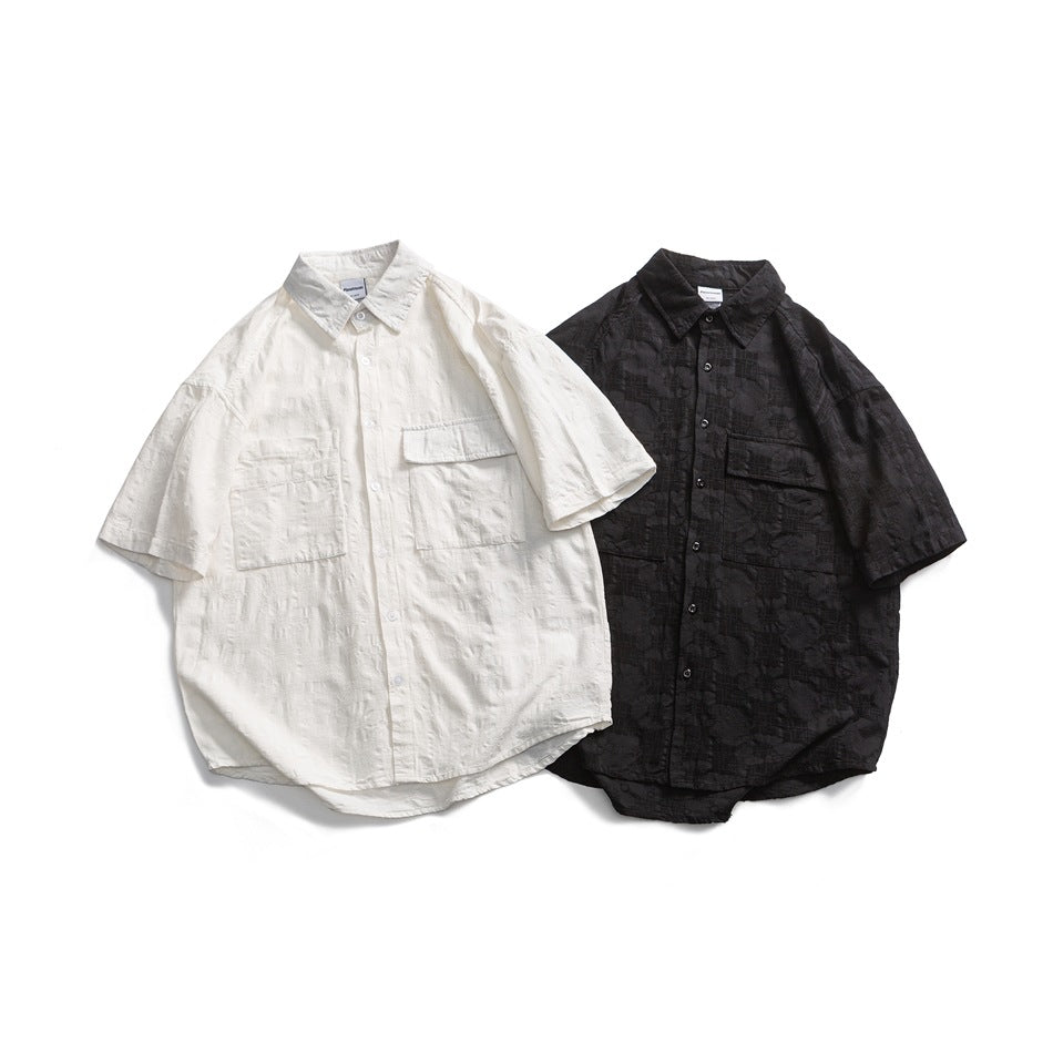 White and black short-sleeve button-up shirts displayed from the front, each with a collar and two chest pockets.