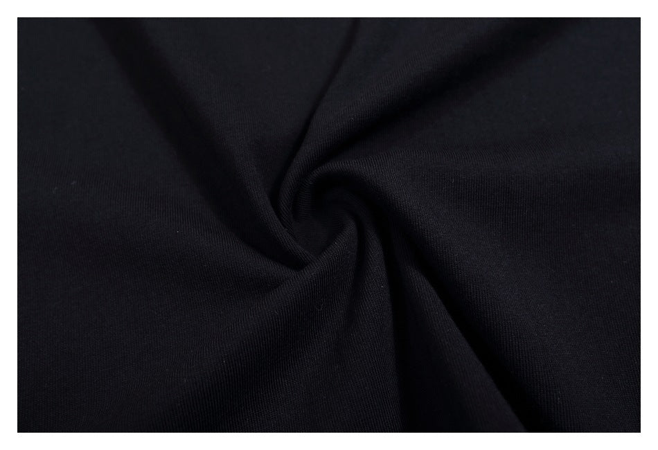 Close-up of the black T-shirt fabric gathered into a spiral fold.