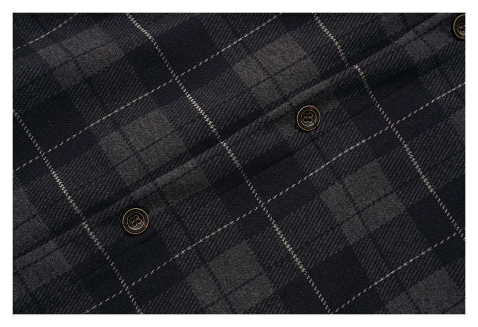 Close-up of the charcoal plaid shirt's button front and patterned fabric.