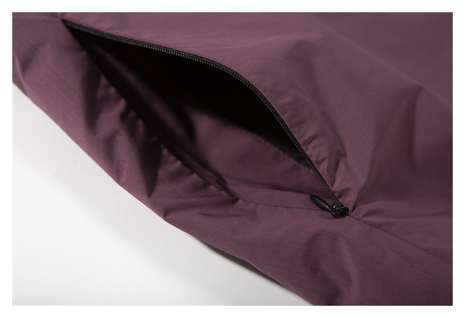 Close-up of a black zippered pocket on the plum vest.