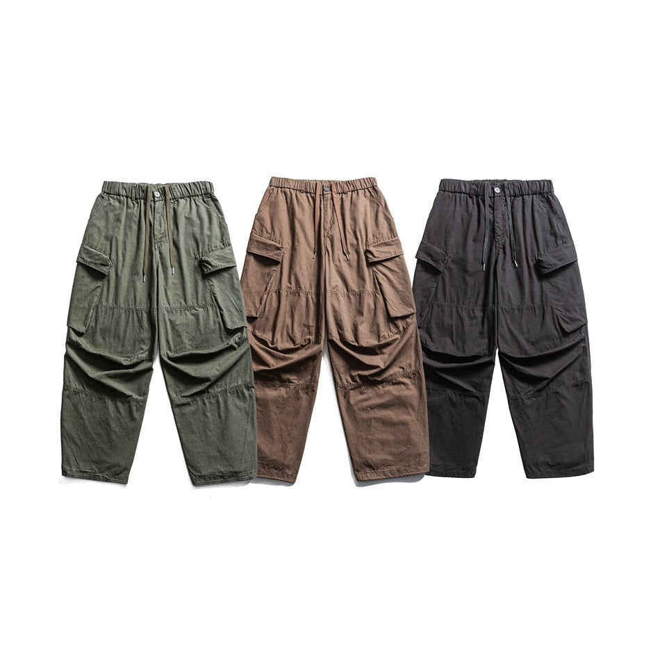Front view of three cargo pants with elastic drawstring waists and large pockets in olive, brown, and black.