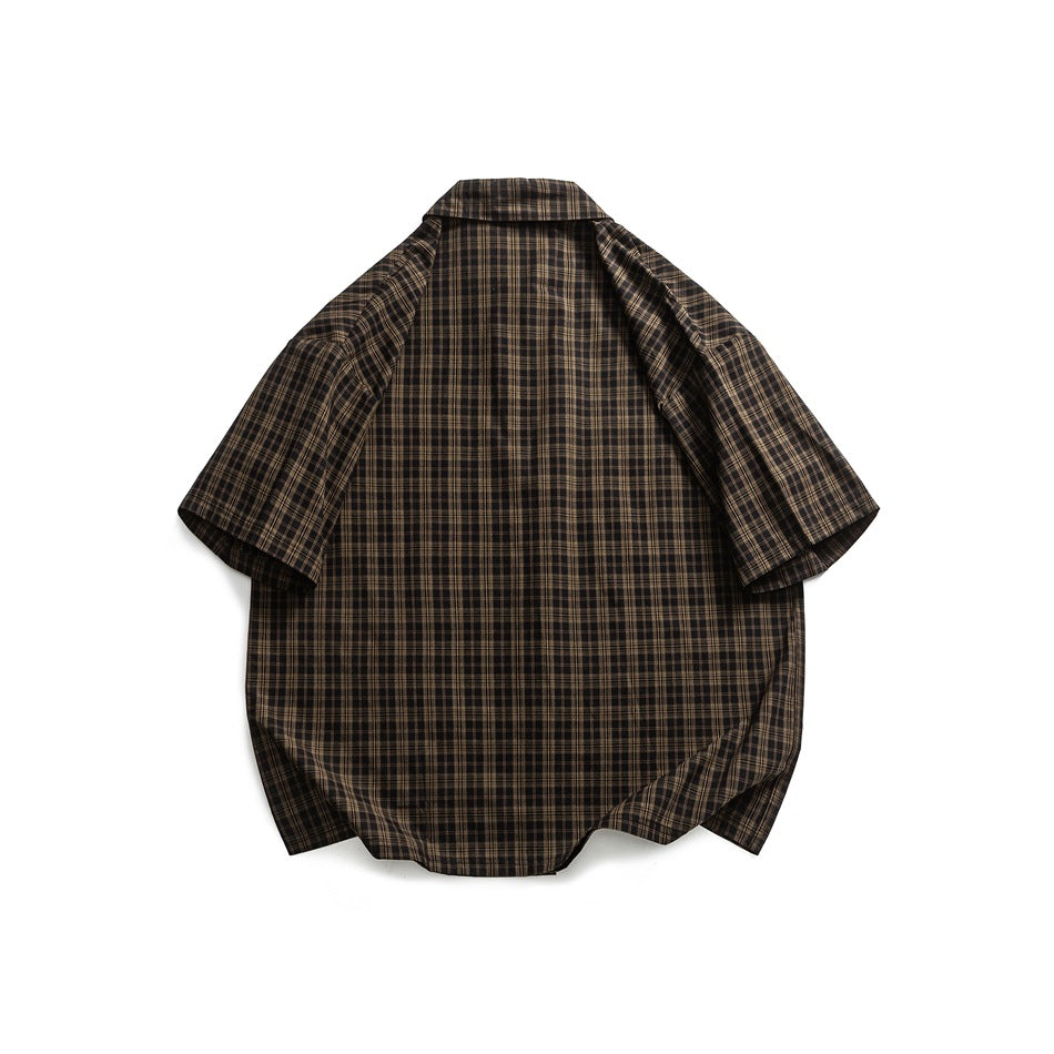Back view of a nearly black brown short-sleeve button-up shirt with a fine tan plaid pattern, laid flat.