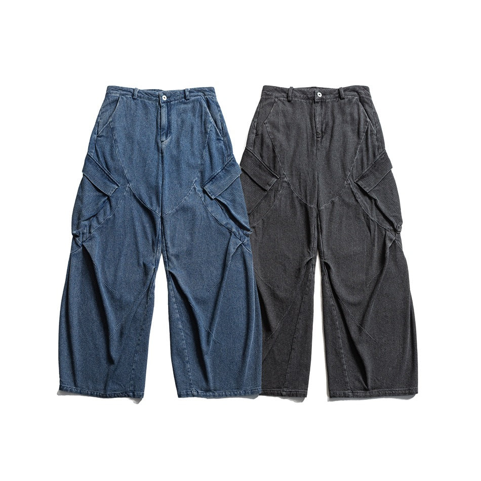 Front view of loose wide-leg trousers with curved panel seams and cargo pockets in blue and charcoal.