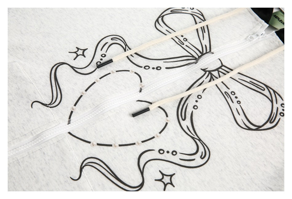 Close-up of black octopus artwork across the heather light-gray front of a hoodie, with a white zipper and cream drawstrings.