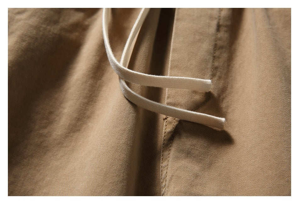 Close-up of the tan bottoms' pale drawstrings and stitched front seam.