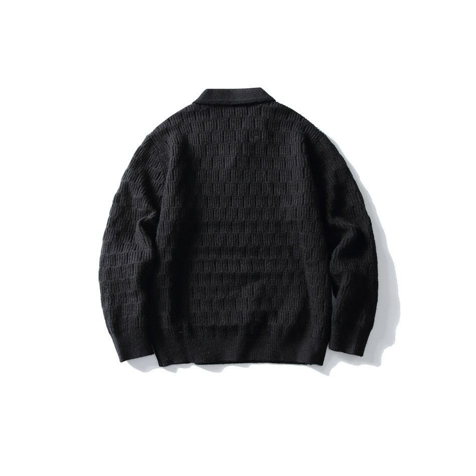 Back view of black textured knit polo-collar sweater with ribbed cuffs and hem, laid flat