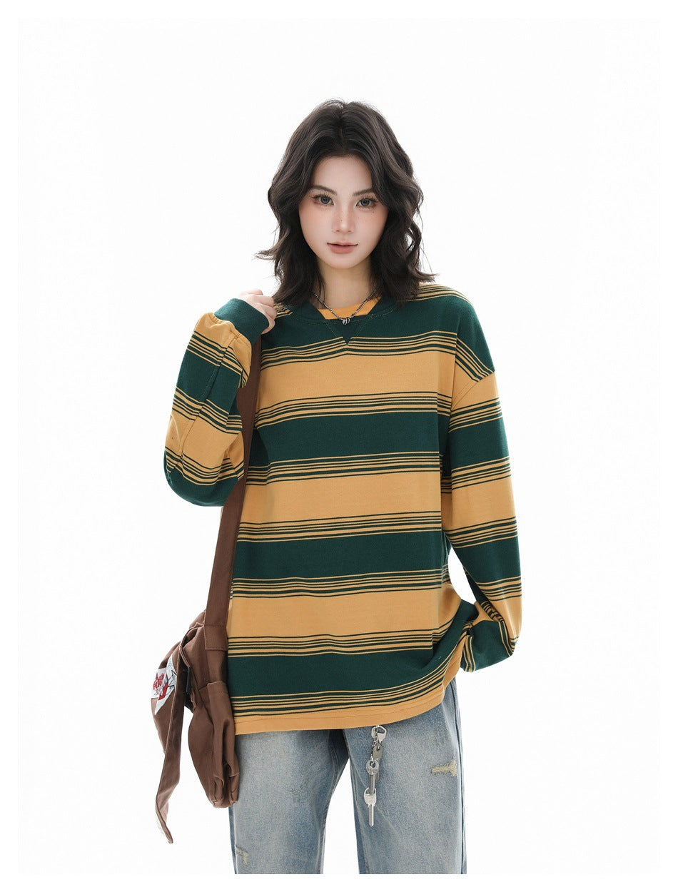 Model in a yellow and green striped long-sleeve sweatshirt with a brown crossbody bag and light jeans