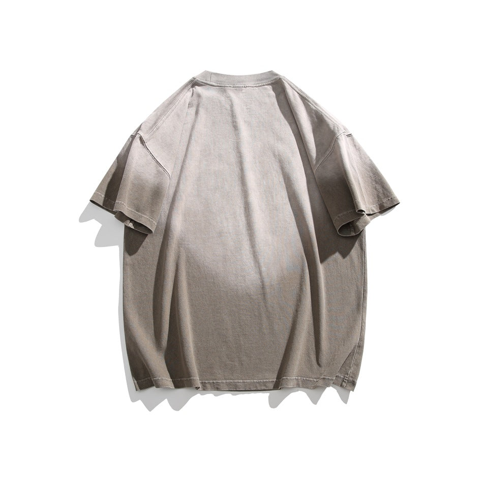 Back view of a plain oversized taupe-gray short-sleeve T-shirt laid flat on white.