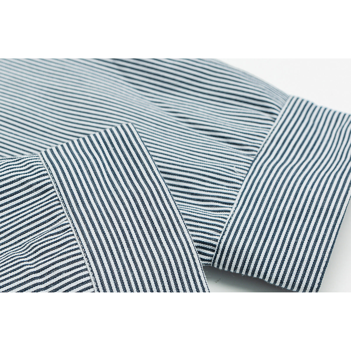 Close-up of a striped jacket sleeve and wide cuff with contrasting stripe directions.