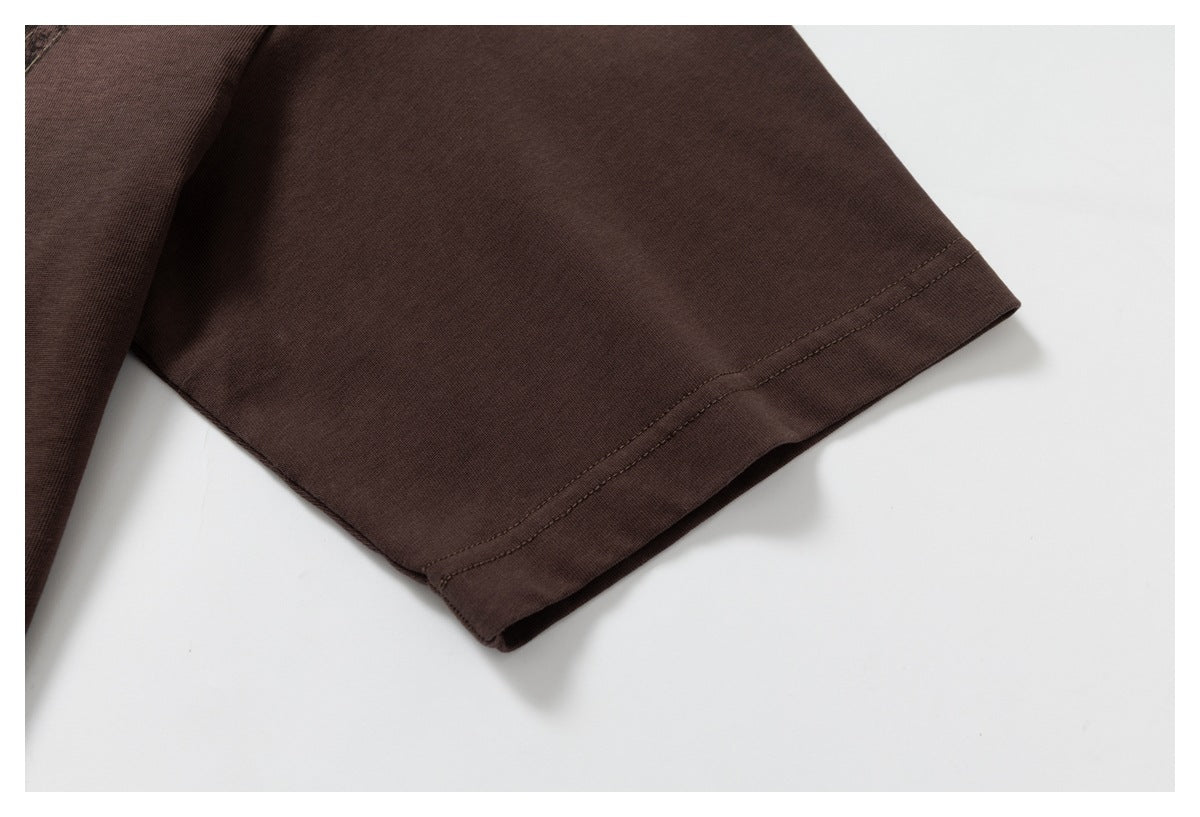 Close-up of the dark brown T-shirt’s short sleeve and stitched hem.