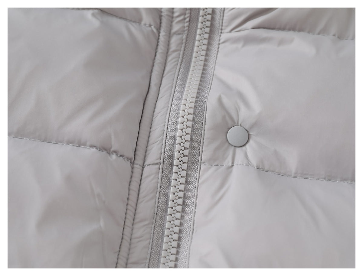 Close-up of the vest's chunky front zipper, round snap, and quilted gray panels.