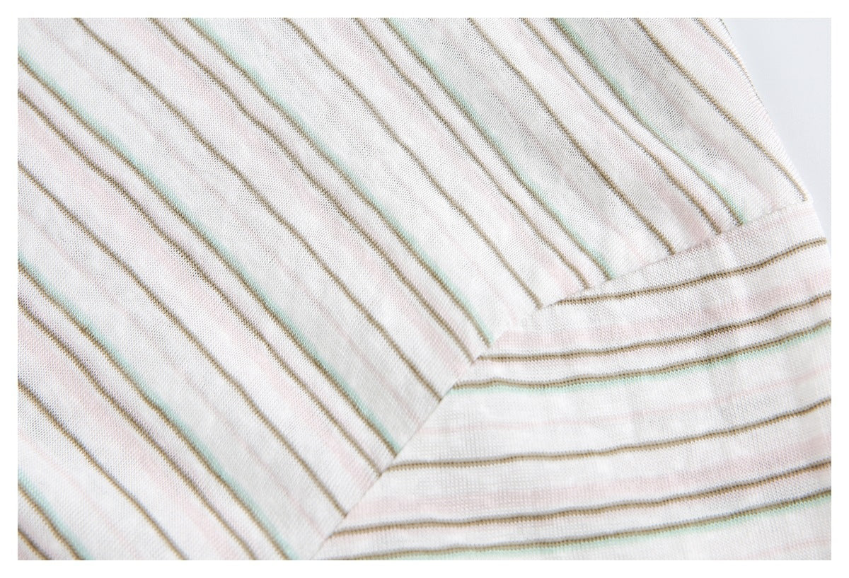 Close-up of a striped off-white knit garment edge with folded seam finishing.