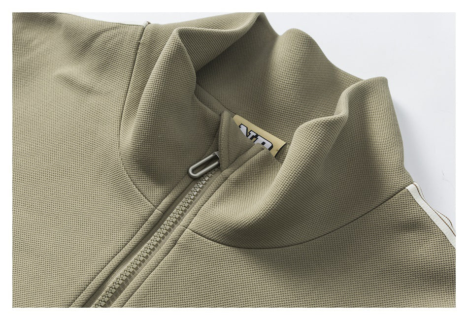 Close-up of an olive zip jacket’s stand collar, zipper and partial inner neck label.